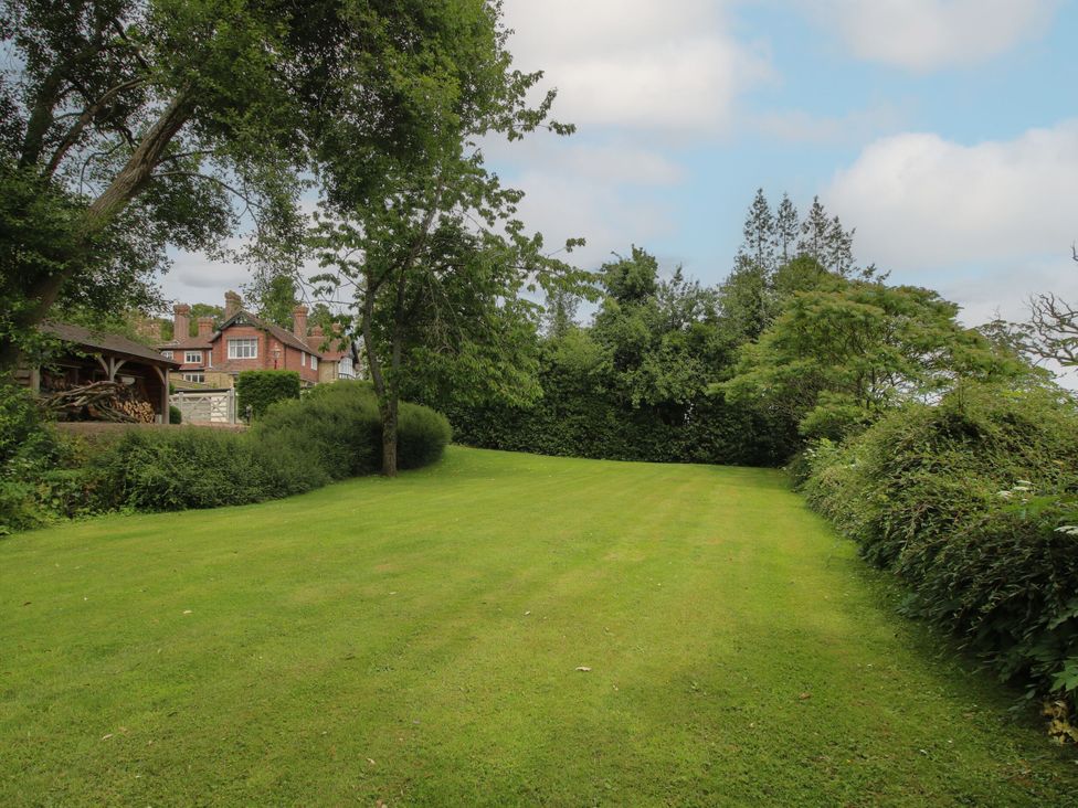 A garden with a lawn and trees at The Old Nursery in Bourton near Much Wenlock