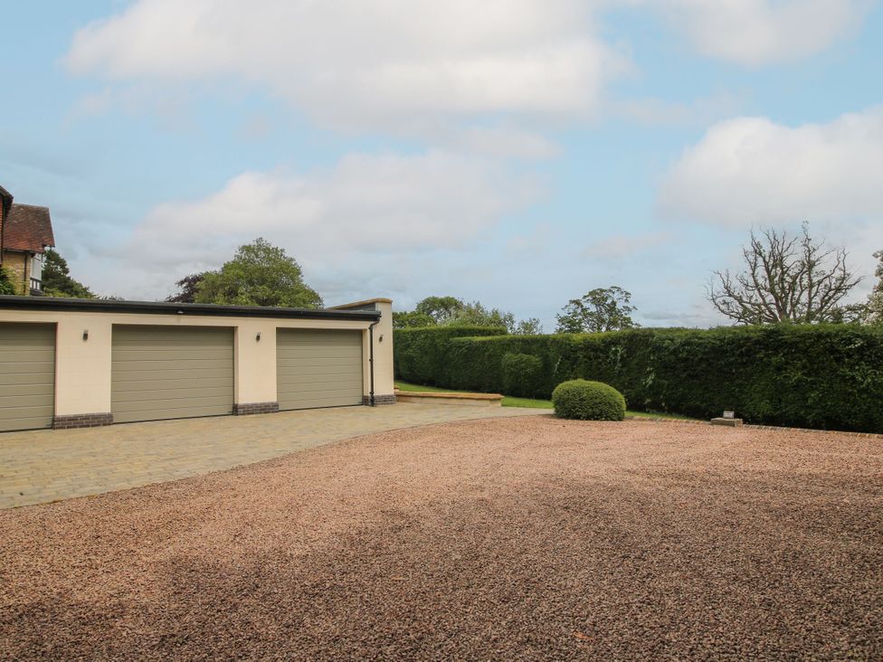 A garage with a gravel driveway at The Old Nursery in Bourton near Much Wenlock