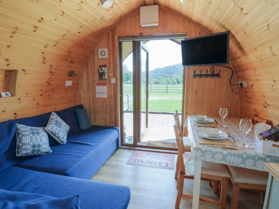 A seating area with a sofa and dining table at Bwthyn Bach Brefi