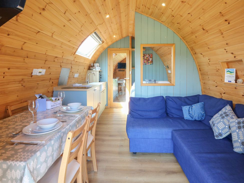 A living room with a sofa and dining area at Bwthyn Bach Brefi