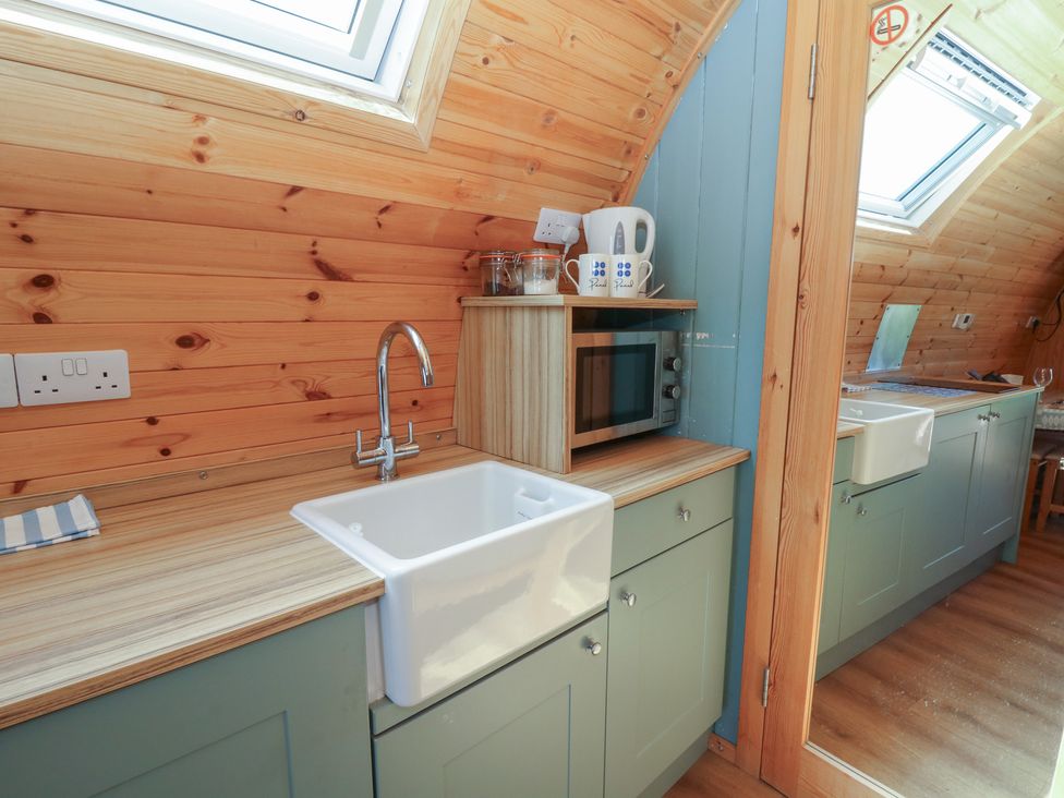 A kitchen with a sink and microwave at Bwthyn Bach Brefi