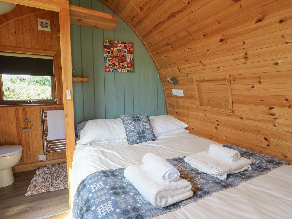 A bedroom with a bed and towels at Bwthyn Bach Brefi 