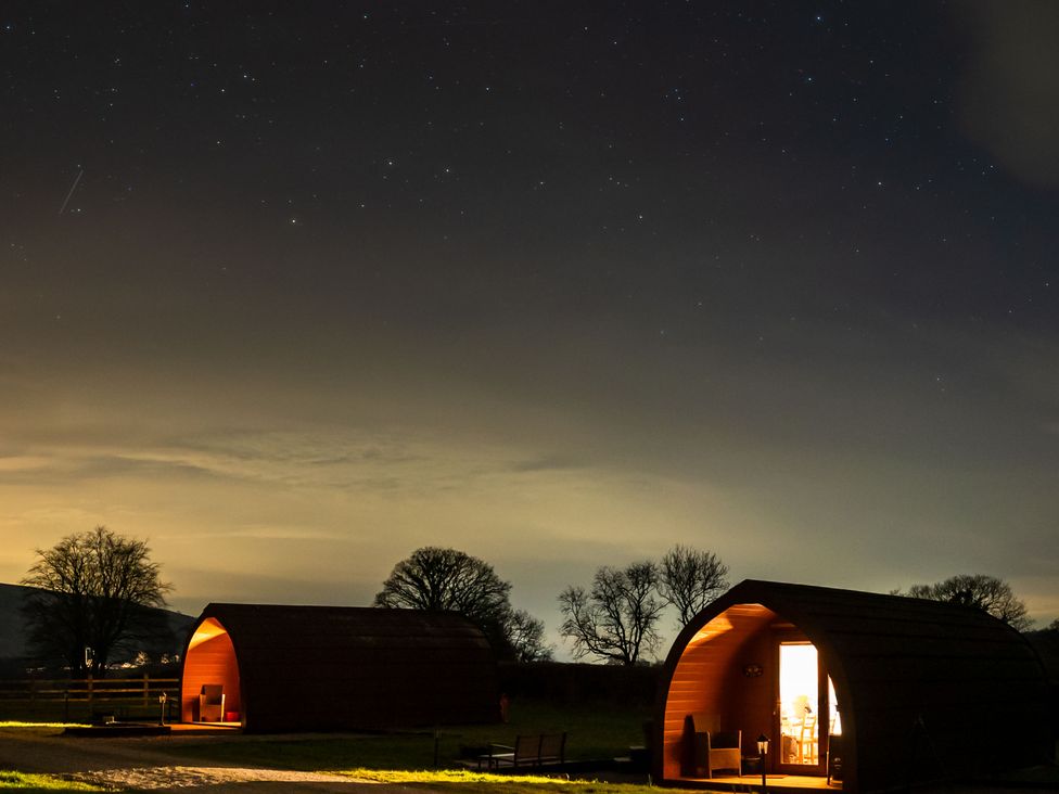 Huts with lights at night under a starry sky at Bwthyn Bach Brefi
