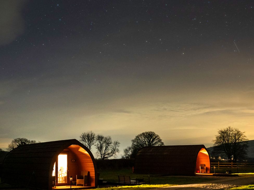 Two cabins with lights on under a starry sky at Bwthyn Bach Brefi