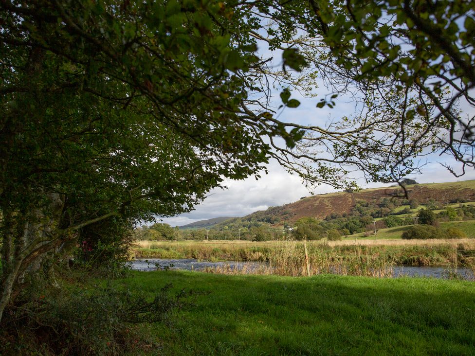 A view of hills and a river surrounded by trees at Bwthyn Bach Brefi