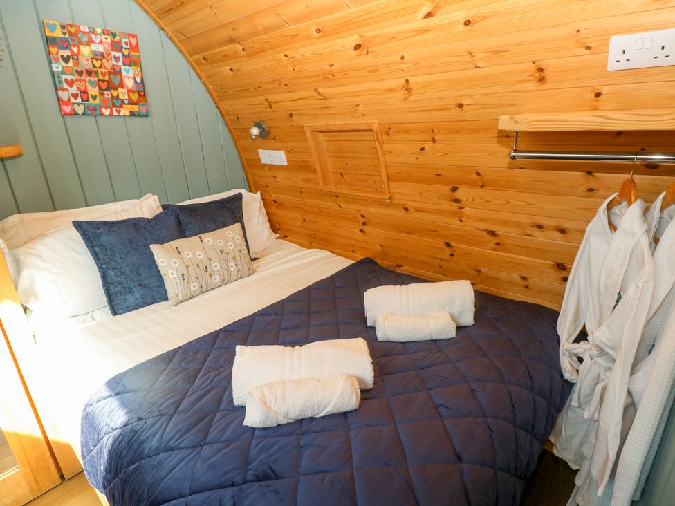 A bedroom with a bed and decorative wall art at Bwthyn Bach Brefi in Llanddewi-Brefi
