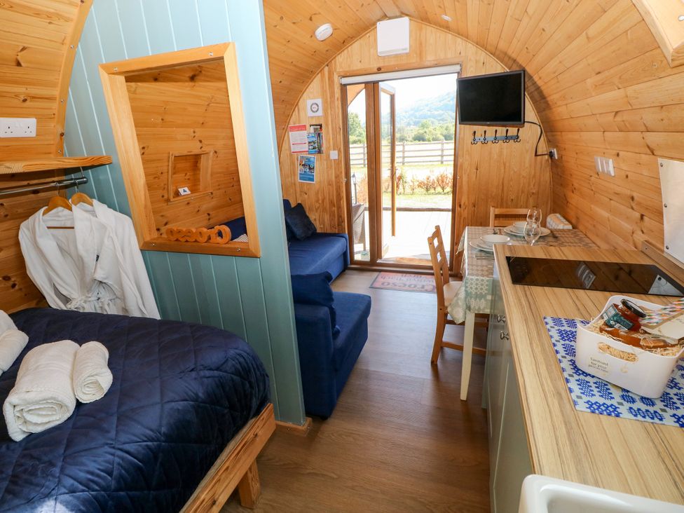 A living space with a bed, sofa, and kitchenette at Bwthyn Bach Brefi in Llanddewi-Brefi