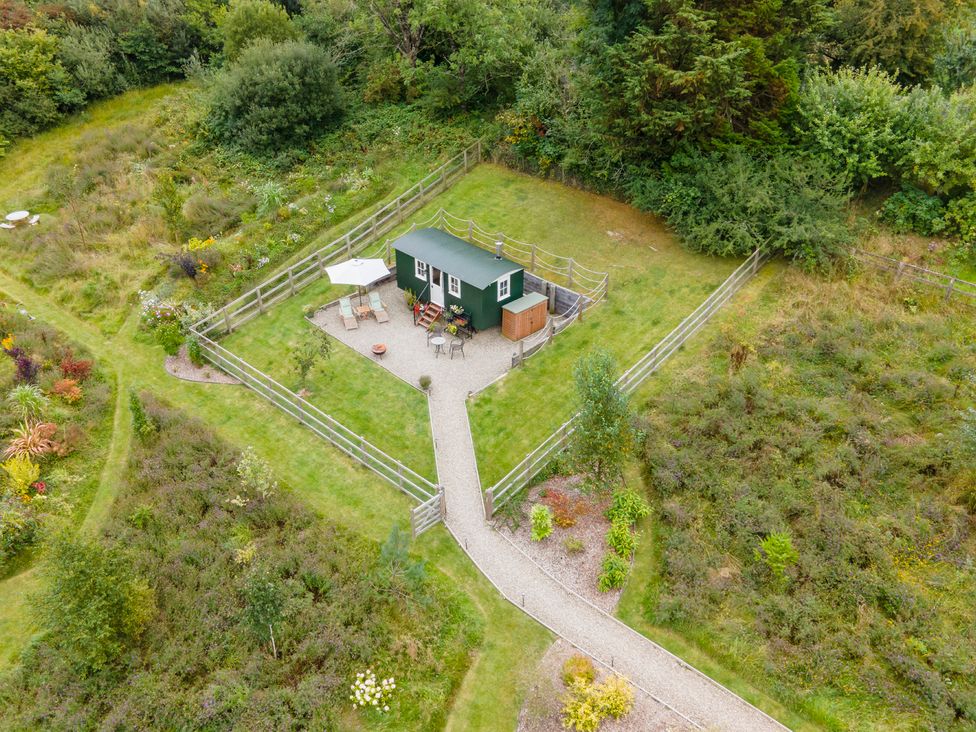 A green cabin with outdoor seating at Onnen in Oakford near Aberaeron