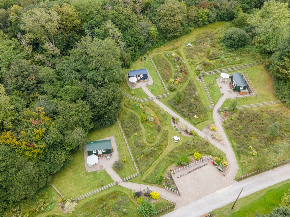An outdoor area with cabins and pathways at Onnen Oakford near Aberaeron