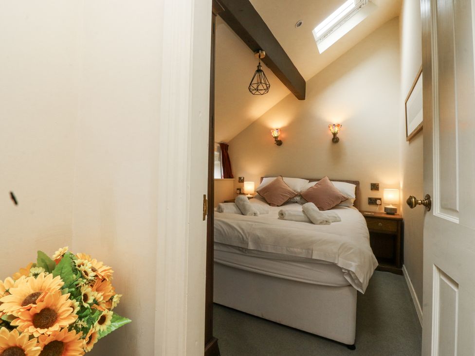 A bedroom with a bed and nightstands at Bridgend Cottage Eastby near Embsay