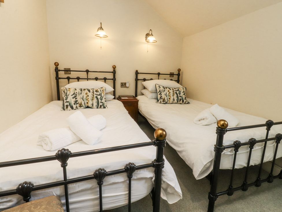 A bedroom with two single beds and a bedside table at Bridgend Cottage Eastby near Embsay