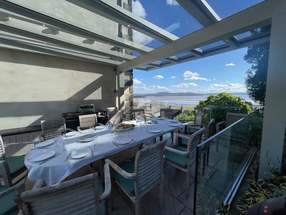 An outdoor dining area with a table and chairs at Victoria Mount Grange-Over-Sands