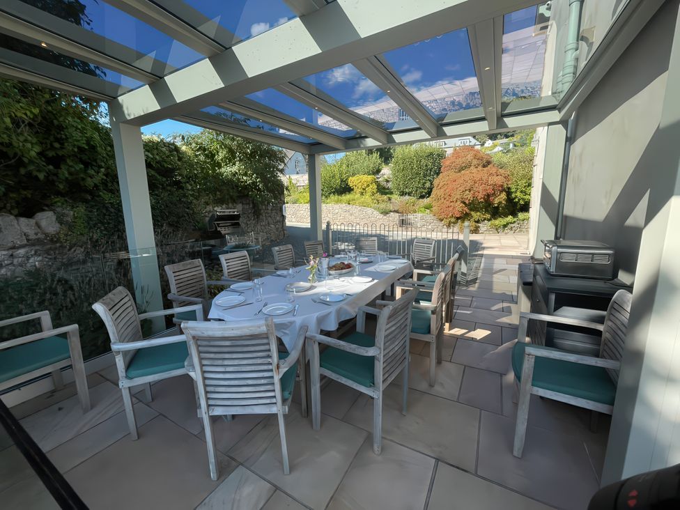 An outdoor dining area with a table and chairs at Victoria Mount in Grange-Over-Sands