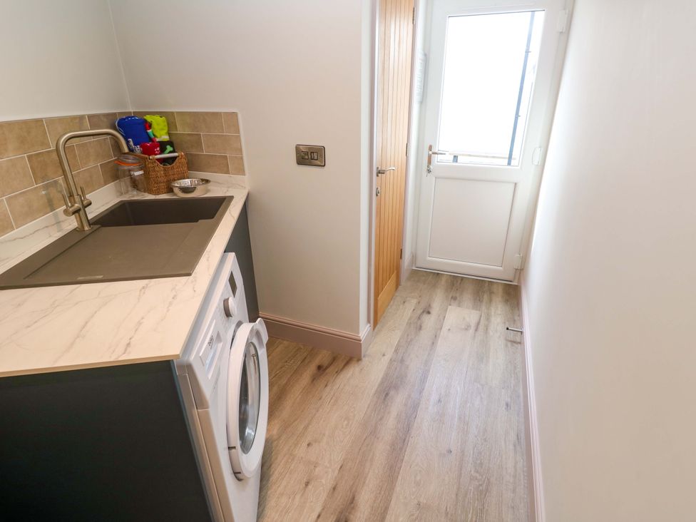 A laundry room with a sink and washing machine at 21 Alverton Street Penzance