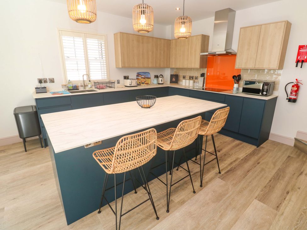 A kitchen with an island and bar stools at 21 Alverton Street Penzance