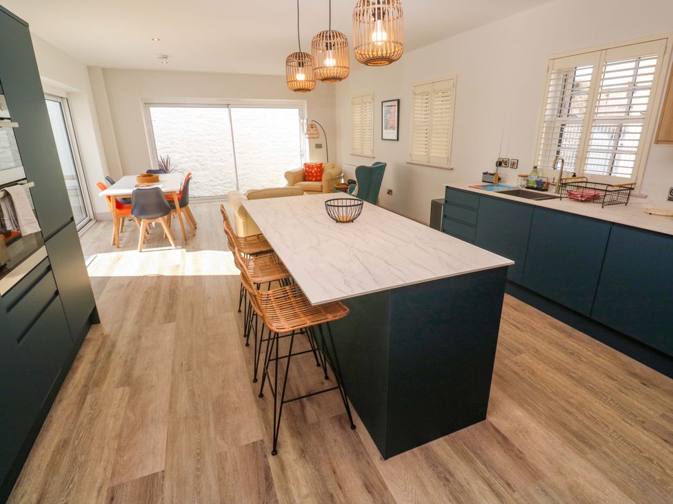 A kitchen with an island and dining table at 21 Alverton Street Penzance