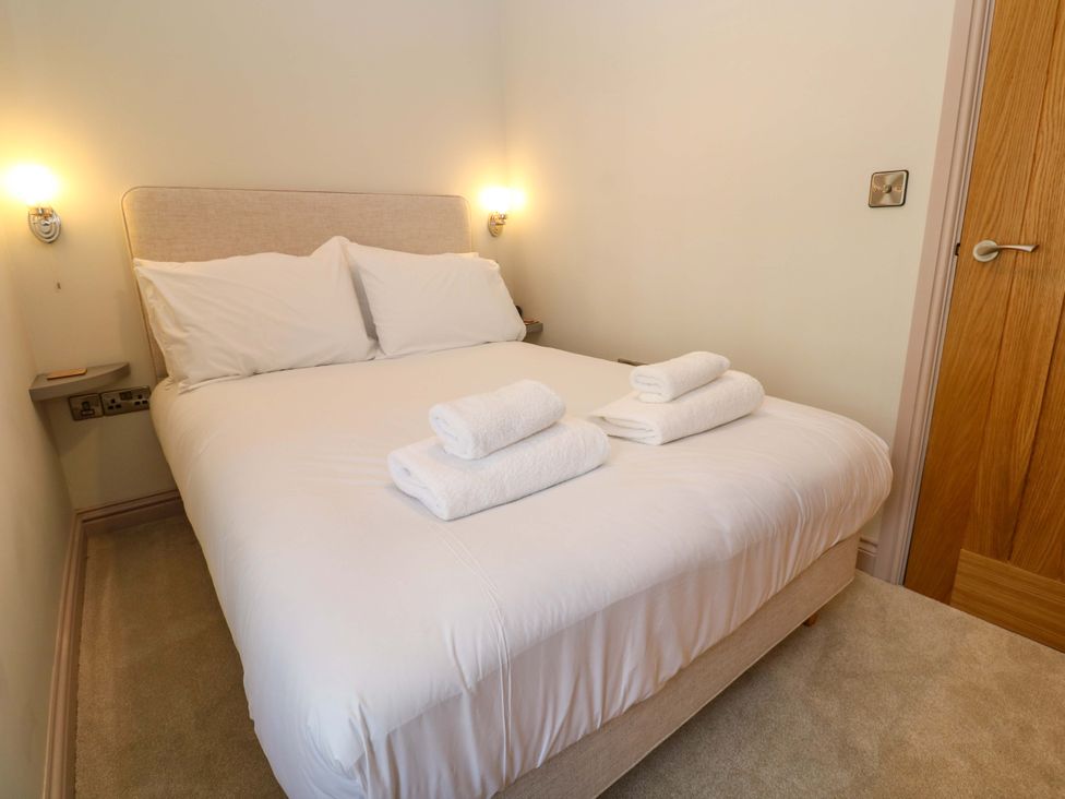 A bedroom with a bed and towels at 21 Alverton Street in Penzance