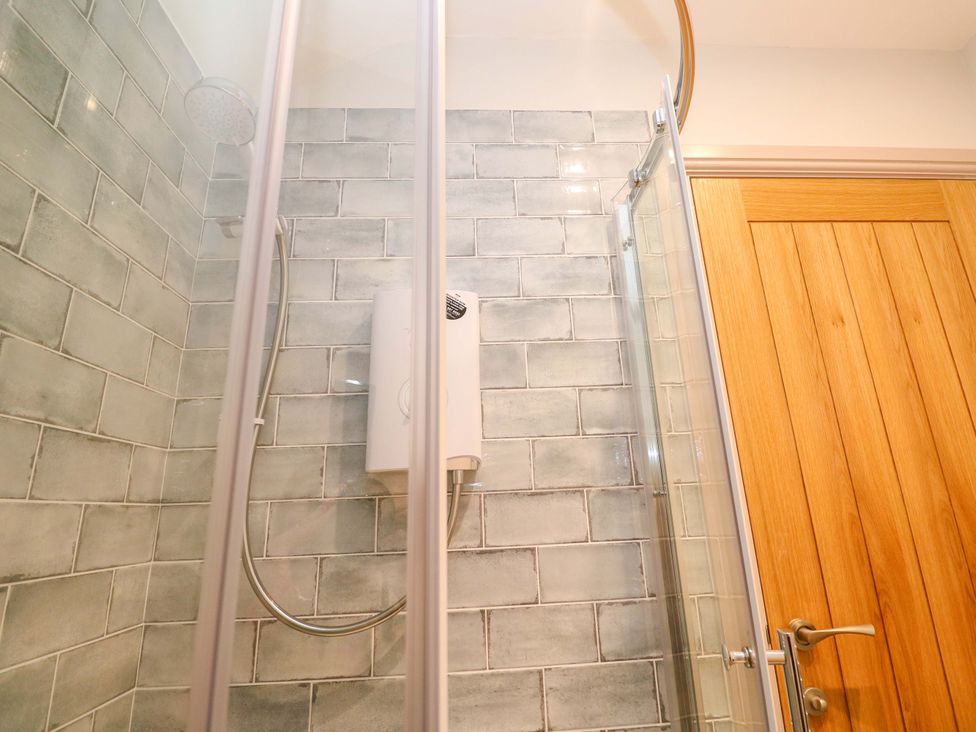 A shower with tiles and panel in a bathroom at 21 Alverton Street Penzance