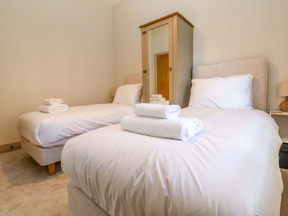 A bedroom with two beds and a wardrobe at 21 Alverton Street in Penzance