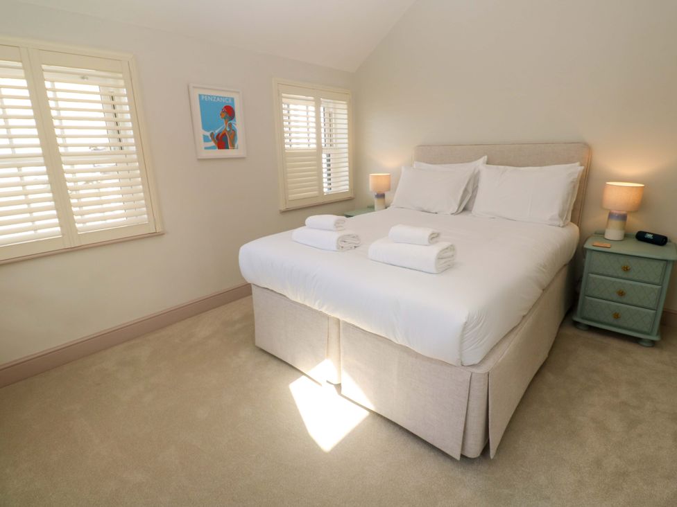 A bedroom with a bed and towels at 21 Alverton Street Penzance