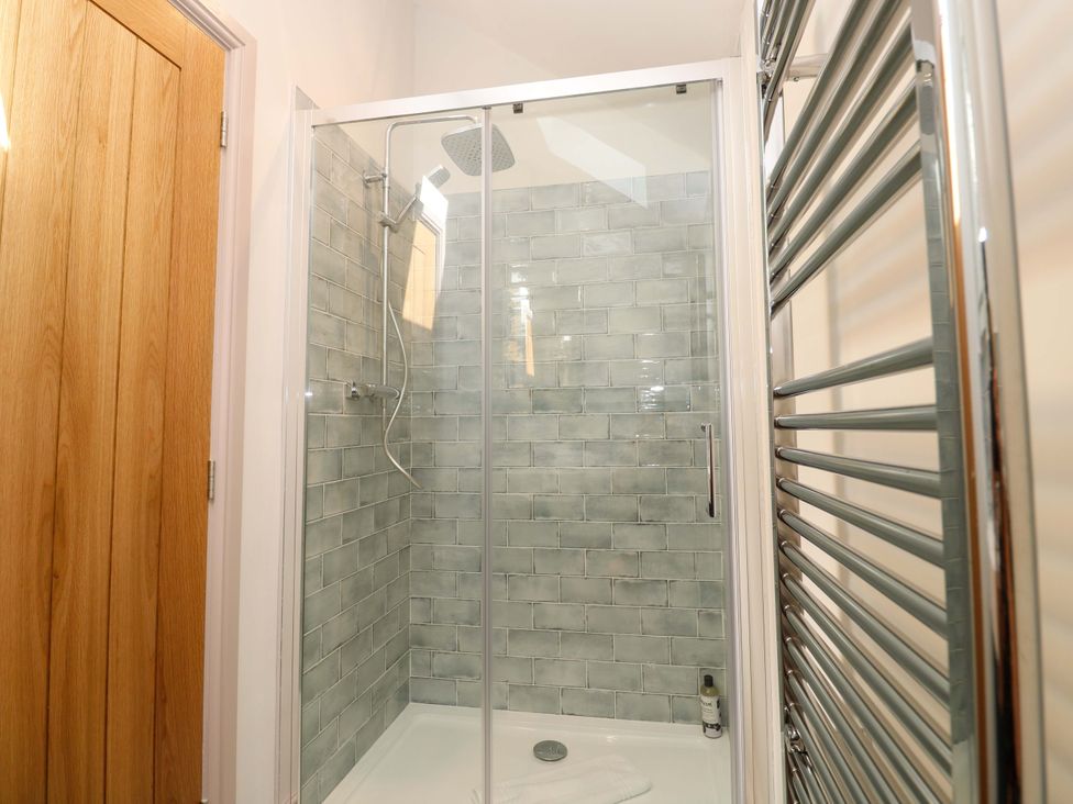 A shower area with tiles and a towel rail at 21 Alverton Street Penzance