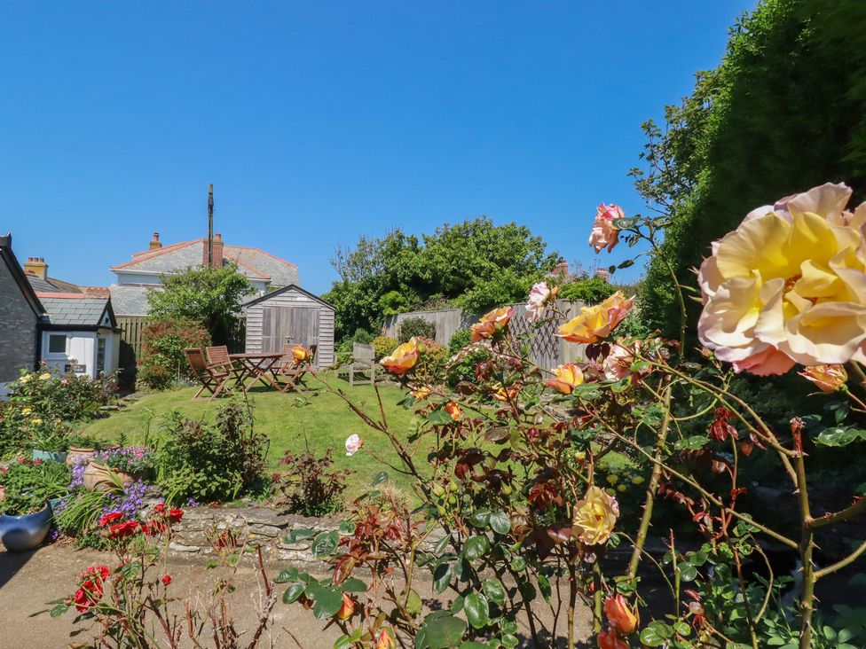 A garden with a table and chairs at Cove Cottage in Tintagel