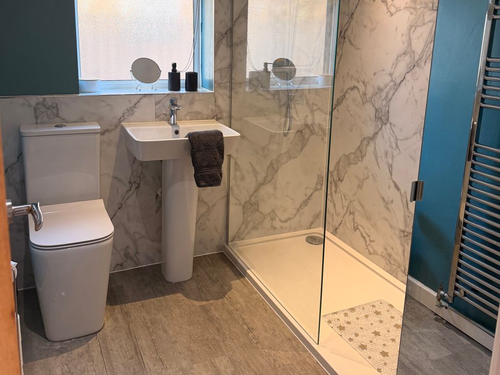 A bathroom featuring a toilet, sink, and shower at Honeybees Haven in Hunstanton