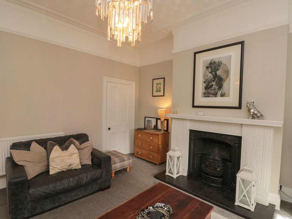 A living room with a sofa and fireplace at Royal Victoria House Scarborough