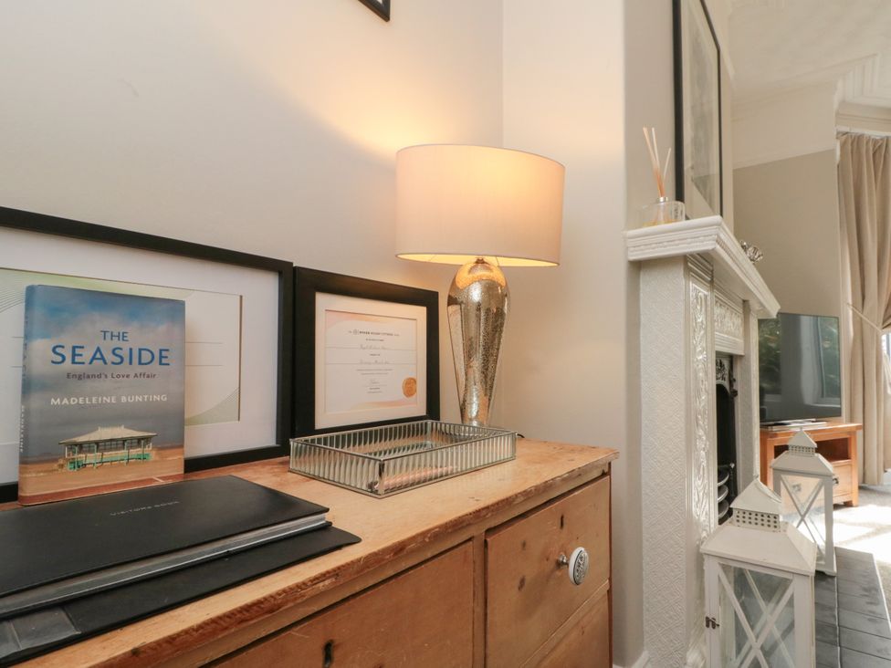 A living room with a book and a lamp on a table at Royal Victoria House in Scarborough