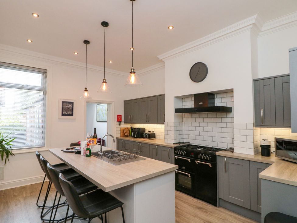 A kitchen with an island and stools at Royal Victoria House in Scarborough
