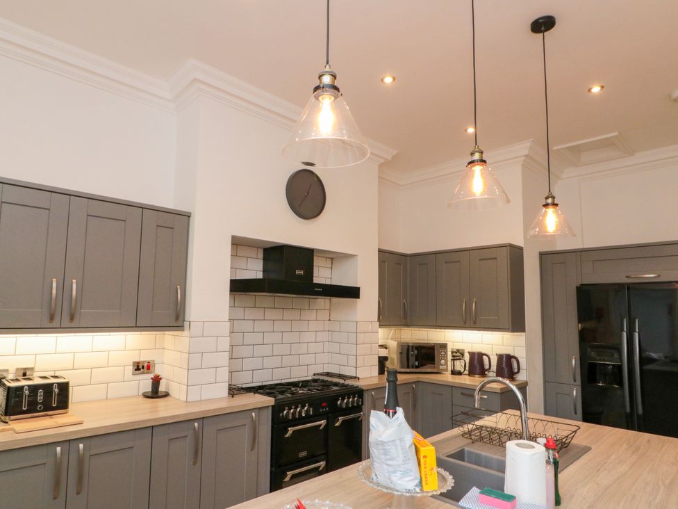 A kitchen with cabinets, sink, and appliances at Royal Victoria House in Scarborough