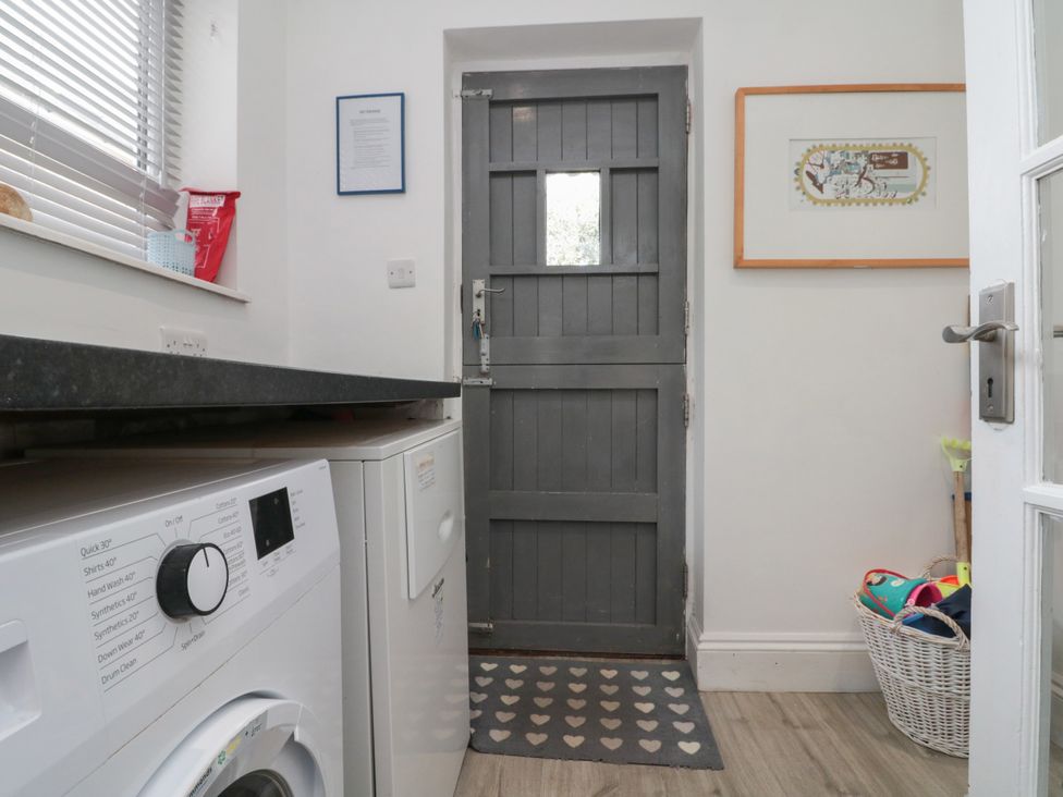 A laundry room with a washing machine and door at Royal Victoria House Scarborough