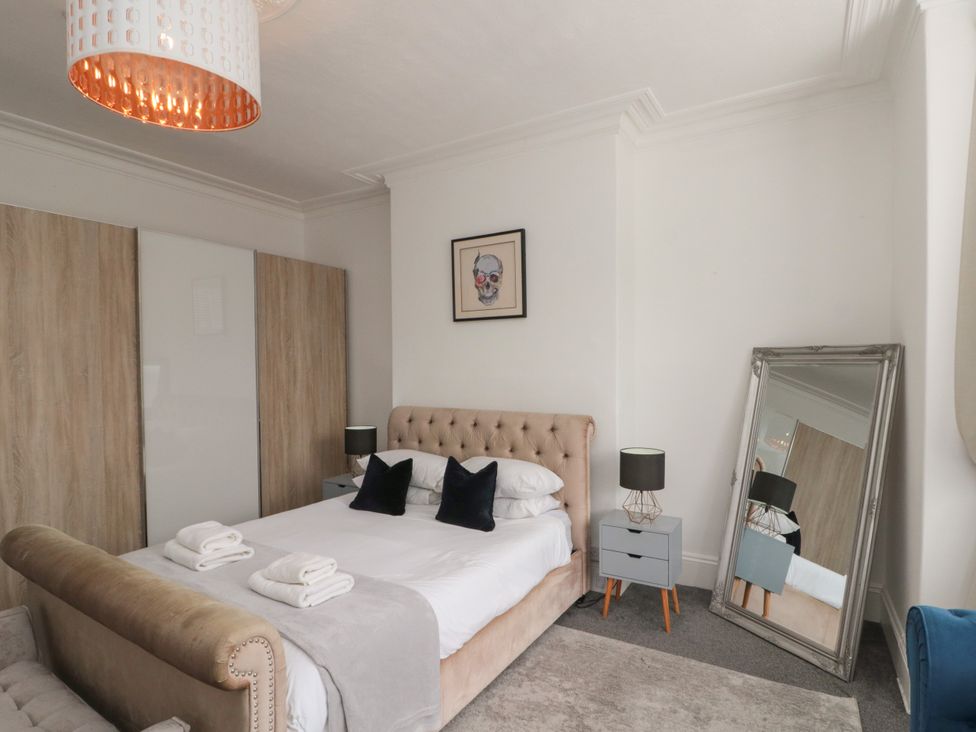 A bedroom with a bed and mirror at Royal Victoria House Scarborough