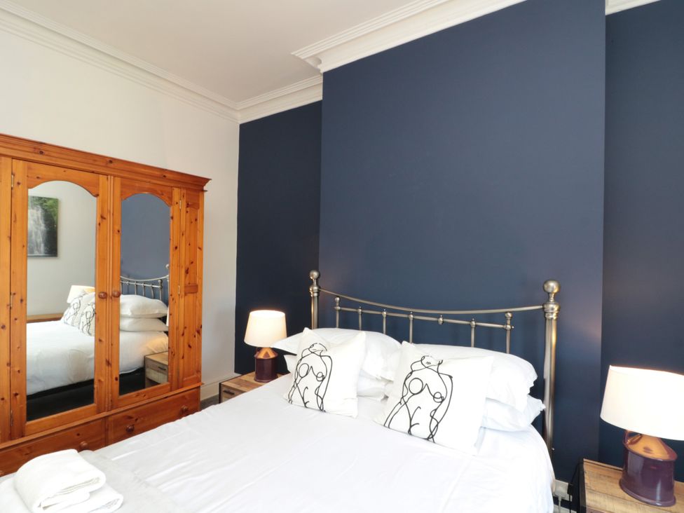 A bedroom with a bed and wardrobe at Royal Victoria House Scarborough