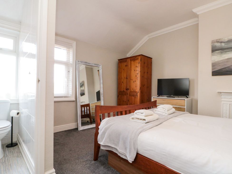 A bedroom with a bed and wardrobe at Royal Victoria House in Scarborough