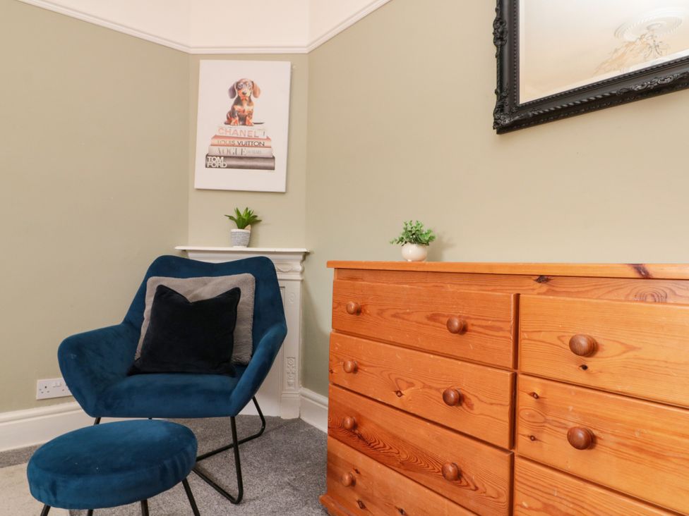 A sitting room with a chair and a dresser at Royal Victoria House Scarborough