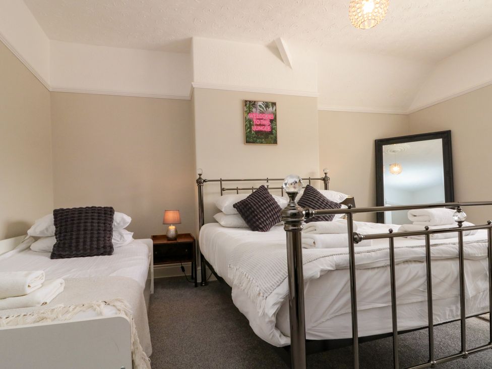 A bedroom with two beds and a mirror at Royal Victoria House Scarborough