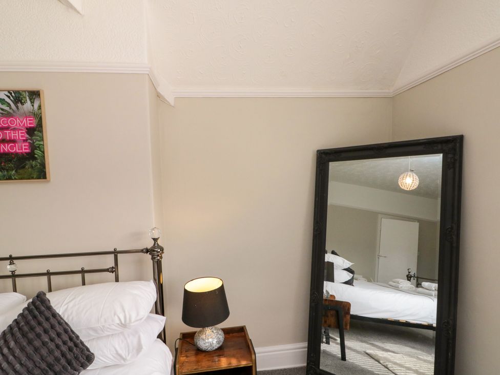 A bedroom with a bed and mirror at Royal Victoria House Scarborough
