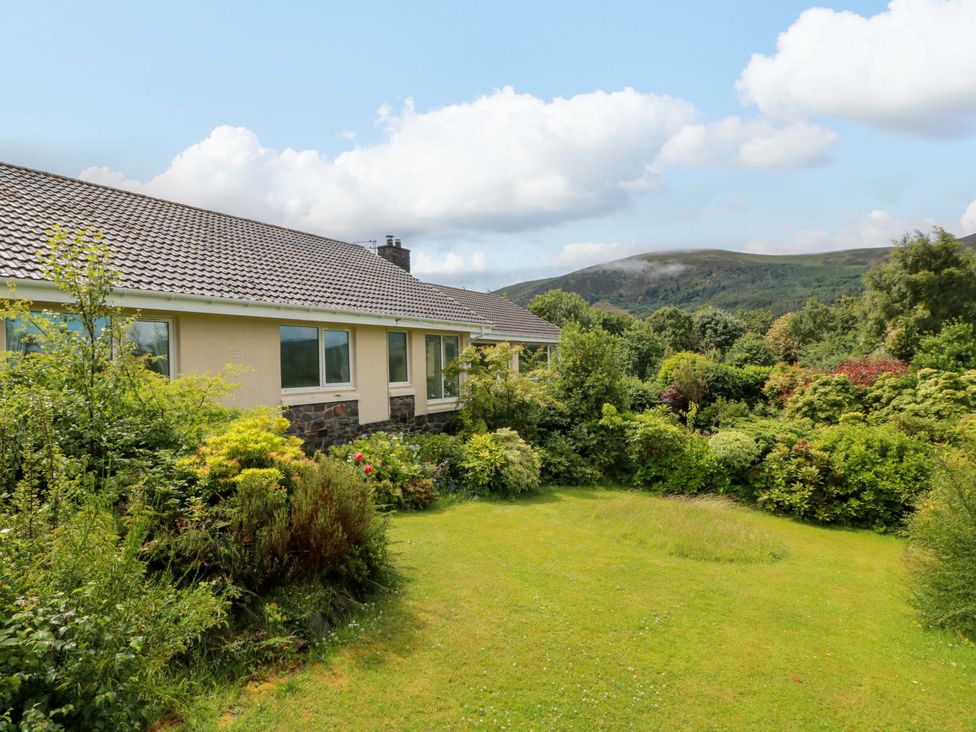 A house with a garden and mountains in the background at Knockendoch in New Abbey