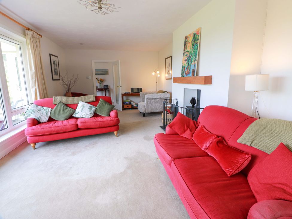 A living room with red sofas and a fireplace at Knockendoch in New Abbey