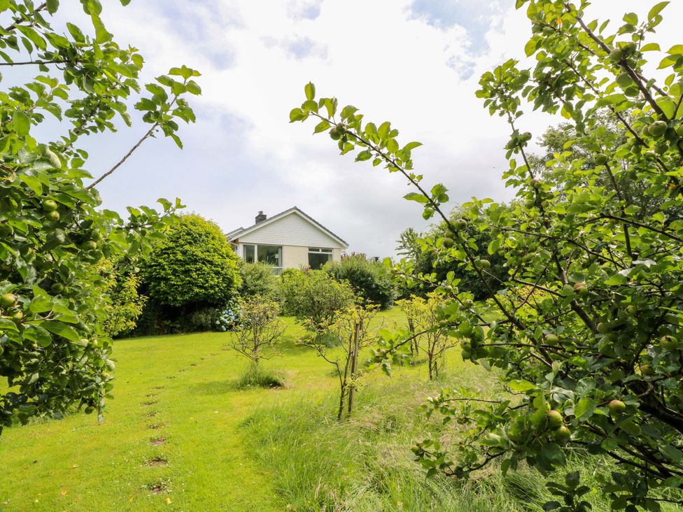 A garden with trees and a house at Knockendoch New Abbey