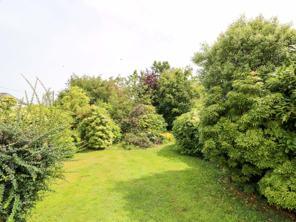A garden with grass and various shrubs and trees at Knockendoch in New Abbey