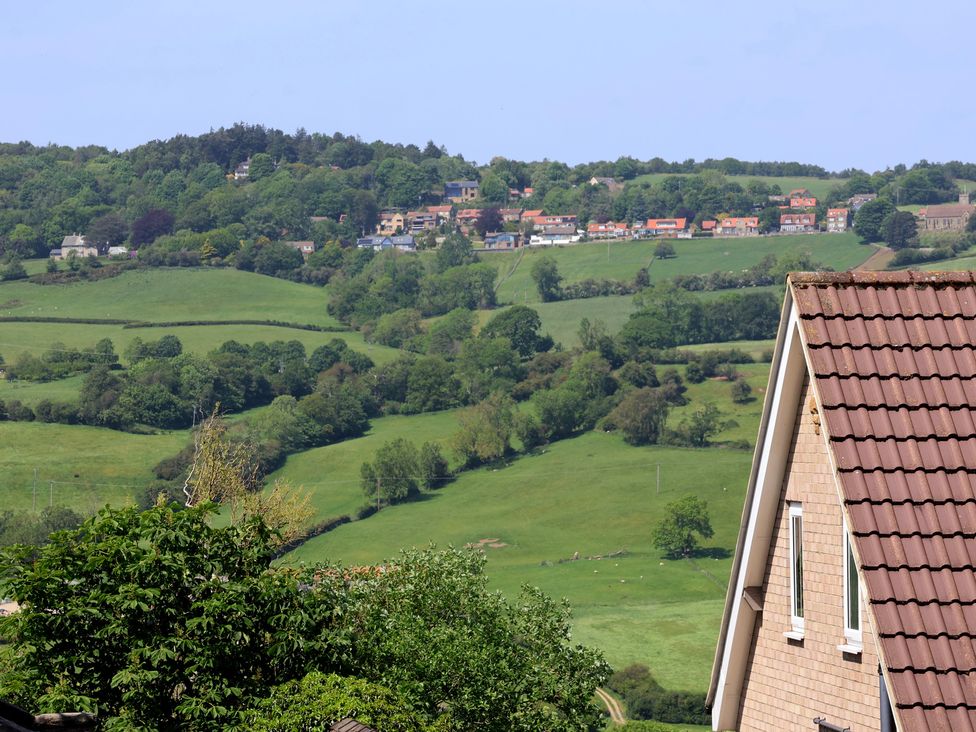 A view of houses and fields with trees on a hill at 21 Eskdaleside Sleights