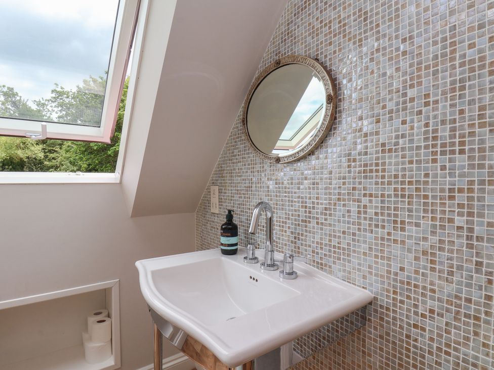 A bathroom with a sink and mirror at 21 Eskdaleside in Sleights