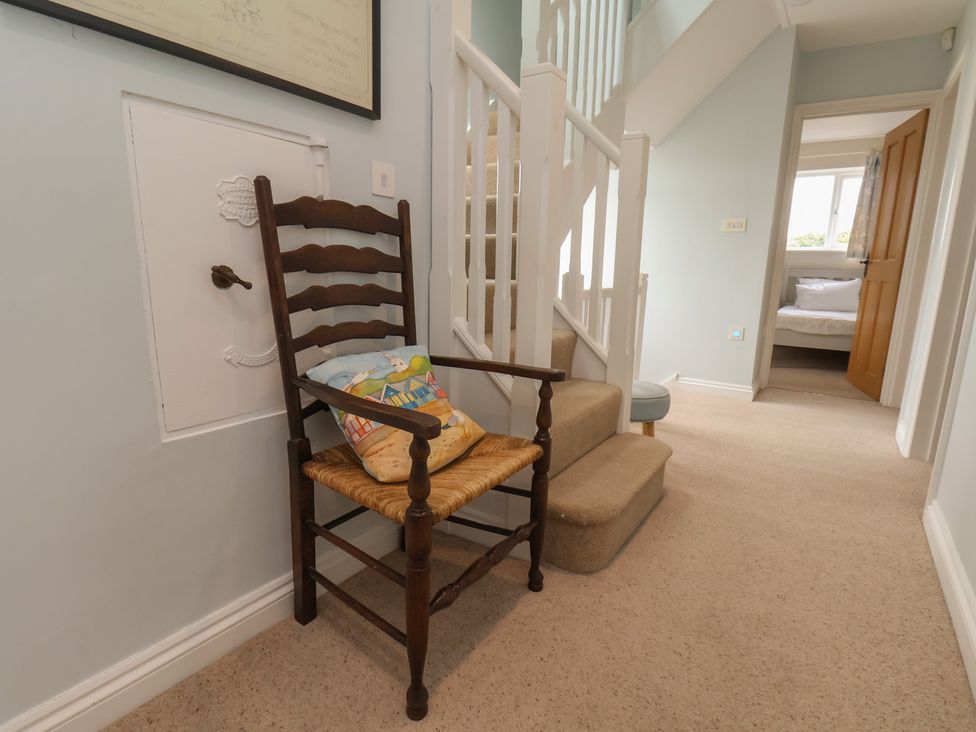 A hallway with a chair and stairs at 21 Eskdaleside Sleights