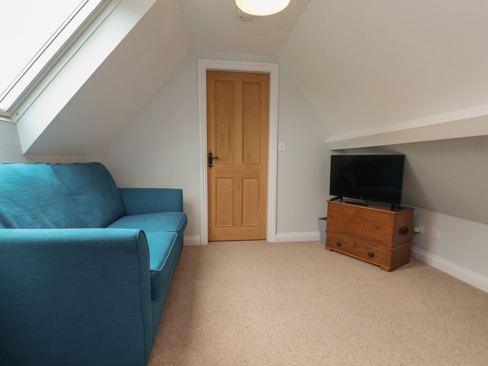 A snug with a sofa and television at 21 Eskdaleside Sleights