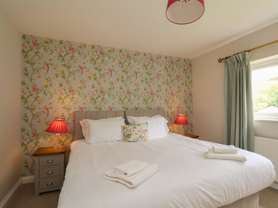 A bedroom with a double bed and bedside lamps at 21 Eskdaleside, Sleights