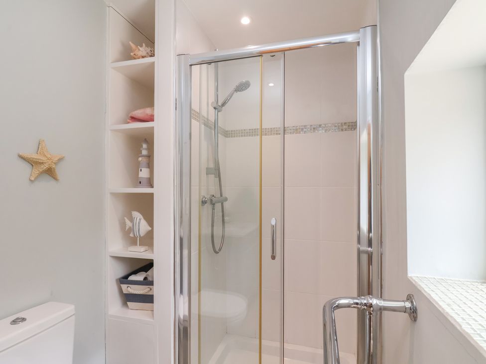 A shower with a toilet and shelf in a bathroom at 21 Eskdaleside Sleights