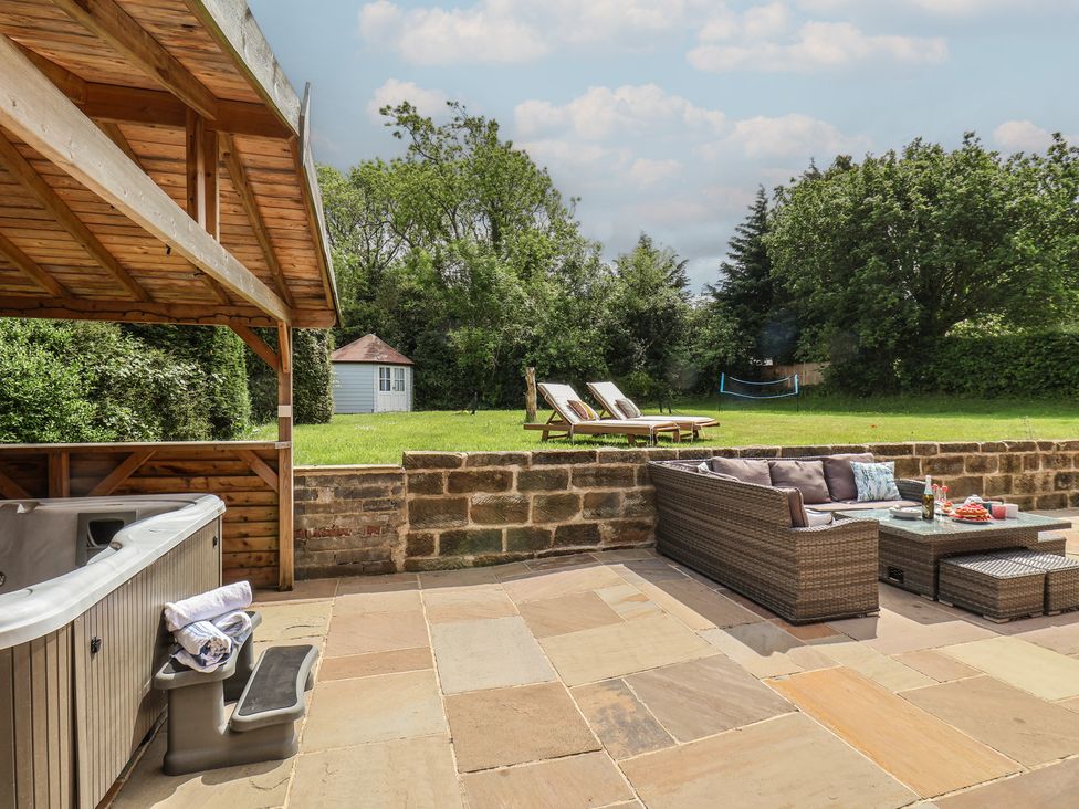 A garden with a hot tub and outdoor seating at 21 Eskdaleside Sleights