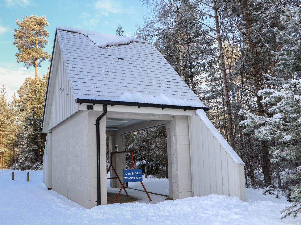 A building with a dog and bike washing area in the snow at Red Deer Lodge Feshiebridge near Aviemore